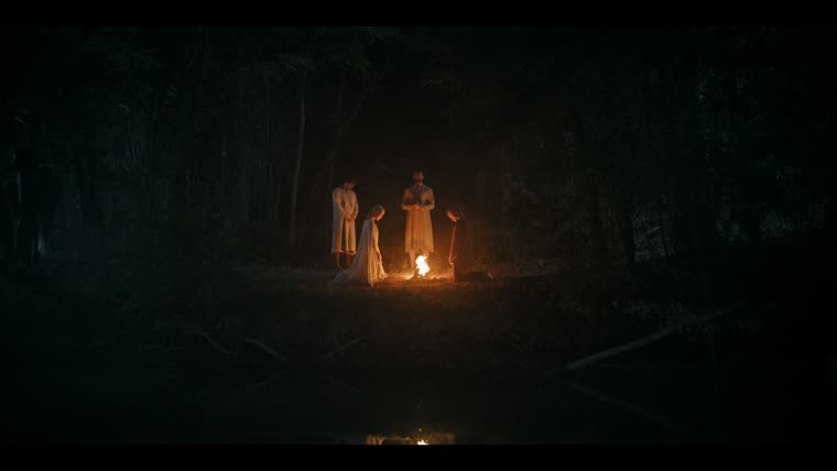 A baptism by firelight at the water’s edge.