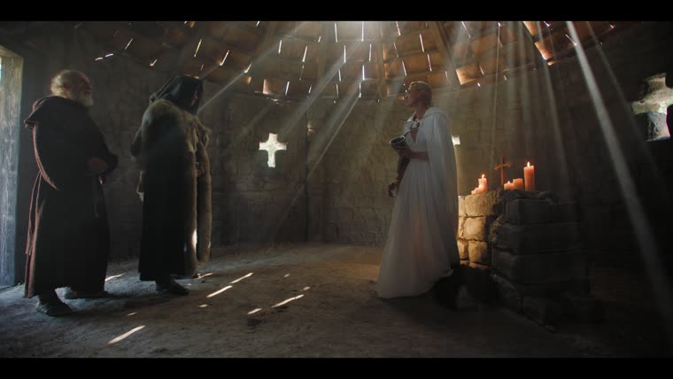 “Hello, Mother” — Merlin (Tom Sharp) comes home to Charis (Rose Reid) at the shrine.