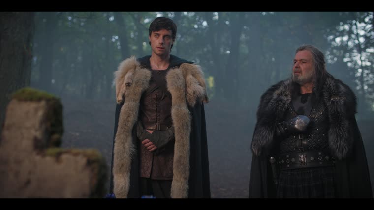 Custennin (Steve Varnom) pledges the North as Merlin (Tom Sharp) dines on ashes.