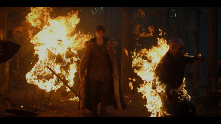 Merlin (Tom Sharp) as death between the flames.